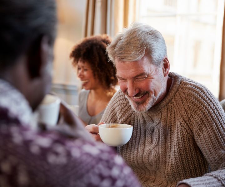 middle-aged-man-meeting-friends-around-table-in-co-2024-10-22-04-07-31-utc.jpg