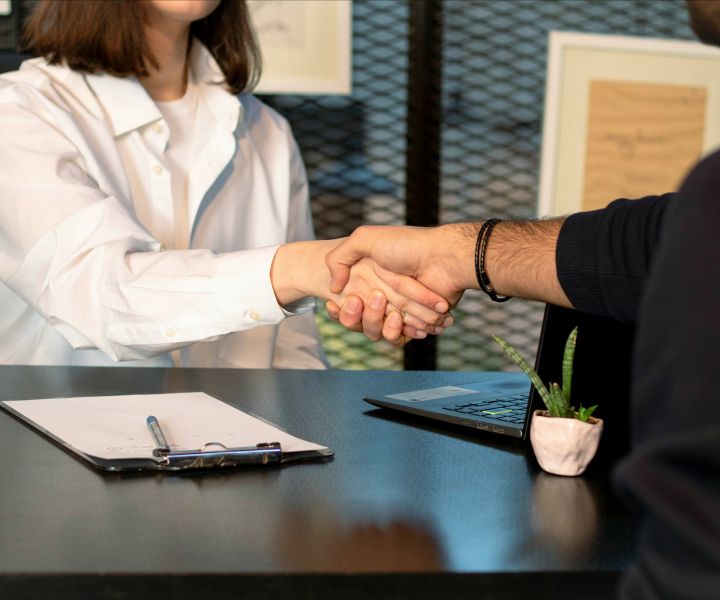 Shaking hands over a desk